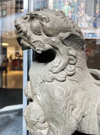 A pair of Chinese carved stone Buddhist lions on later red-lacquered wooden stands, Fujian, Qing