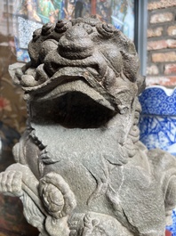 A pair of Chinese carved stone Buddhist lions on later red-lacquered wooden stands, Fujian, Qing
