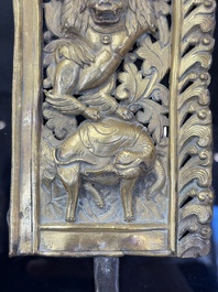A fine Tibetan gilt-copper repouss&eacute; plaque depicting a Dharmapala, a lion and an elephant, on a later mount, 18th C.