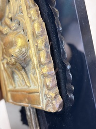 A fine Tibetan gilt-copper repouss&eacute; plaque depicting a Dharmapala, a lion and an elephant, on a later mount, 18th C.
