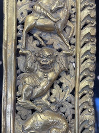 A fine Tibetan gilt-copper repouss&eacute; plaque depicting a Dharmapala, a lion and an elephant, on a later mount, 18th C.