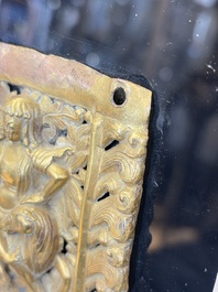 A fine Tibetan gilt-copper repouss&eacute; plaque depicting a Dharmapala, a lion and an elephant, on a later mount, 18th C.