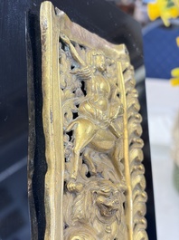 A fine Tibetan gilt-copper repouss&eacute; plaque depicting a Dharmapala, a lion and an elephant, on a later mount, 18th C.