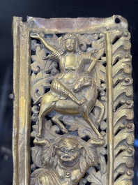 A fine Tibetan gilt-copper repouss&eacute; plaque depicting a Dharmapala, a lion and an elephant, on a later mount, 18th C.