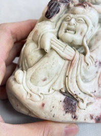 A Chinese stone group of 'Luohan' on wooden stand, Republic