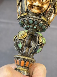 A Tibetan parcel-gilt silver and iron phurba inlaid with precious stones, red coral and bone, 19th C.