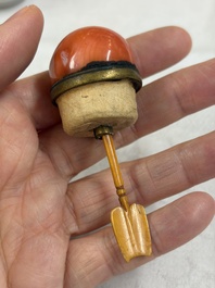 A Chinese gilt-decorated iron-red 'Buddhist Lions' snuff bottle with a red coral stopper, Buddhist Lion mark, Republic