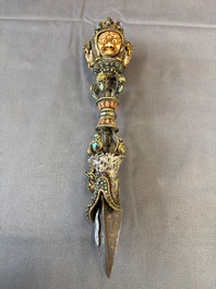 A Tibetan parcel-gilt silver and iron phurba inlaid with precious stones, red coral and bone, 19th C.