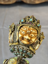 A Tibetan parcel-gilt silver and iron phurba inlaid with precious stones, red coral and bone, 19th C.