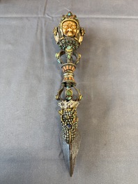 A Tibetan parcel-gilt silver and iron phurba inlaid with precious stones, red coral and bone, 19th C.