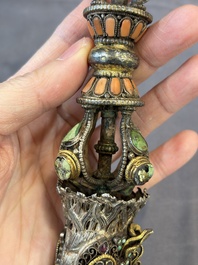A Tibetan parcel-gilt silver and iron phurba inlaid with precious stones, red coral and bone, 19th C.