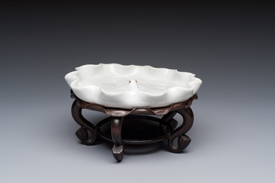 A Chinese Dehua blanc de Chine 'Lotus Leaf and Frog' brush washer on a wooden stand, Kangxi/Yongzheng