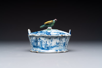 A blue and white Dutch Delft butter tub with a polychrome bird-shaped finial, 18th C.