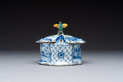 A blue and white Dutch Delft butter tub with a polychrome bird-shaped finial, 18th C.