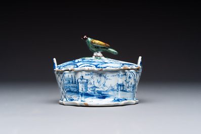 A blue and white Dutch Delft butter tub with a polychrome bird-shaped finial, 18th C.