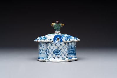 A blue and white Dutch Delft butter tub with a polychrome bird-shaped finial, 18th C.