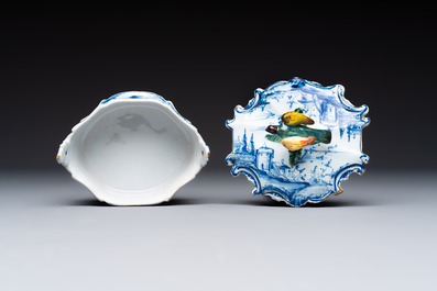 A blue and white Dutch Delft butter tub with a polychrome bird-shaped finial, 18th C.