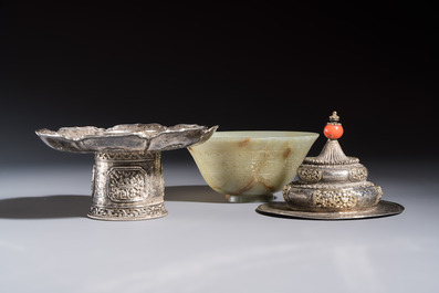 A Tibetan ritual jade bowl with a red coral-mounted silver cover and a stand, 19th C.
