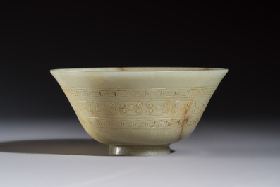 A Tibetan ritual jade bowl with a red coral-mounted silver cover and a stand, 19th C.