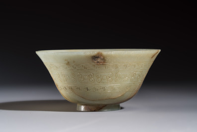 A Tibetan ritual jade bowl with a red coral-mounted silver cover and a stand, 19th C.