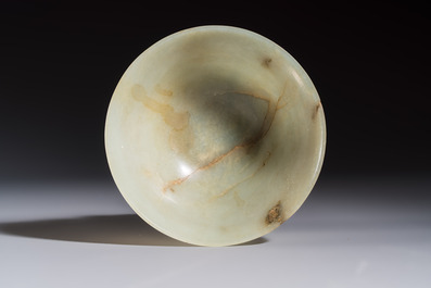 A Tibetan ritual jade bowl with a red coral-mounted silver cover and a stand, 19th C.