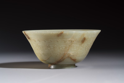 A Tibetan ritual jade bowl with a red coral-mounted silver cover and a stand, 19th C.