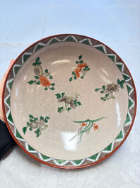 An unusual Chinese famille verte copper-red-ground shallow bowl with floral design, 19th C.