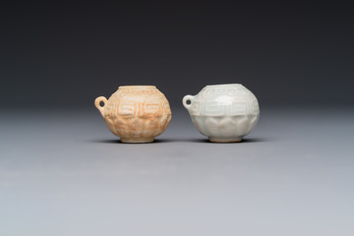 A pair of Chinese bird feeders with moulded design, one unglazed, on later wooden stands, Song