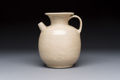 A Chinese cream-glazed ewer with a barrel-shaped body, Hebei/Henan provinces, Tang/Five Dynasties