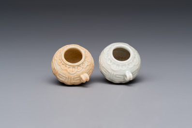 A pair of Chinese bird feeders with moulded design, one unglazed, on later wooden stands, Song