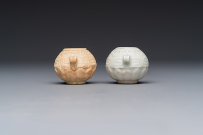 A pair of Chinese bird feeders with moulded design, one unglazed, on later wooden stands, Song