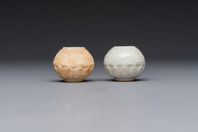 A pair of Chinese bird feeders with moulded design, one unglazed, on later wooden stands, Song