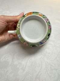 A Chinese Canton famille rose cup and saucer with figures in a garden, 19th C.