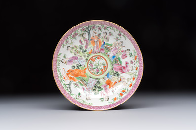 A Chinese Canton famille rose cup and saucer with figures in a garden, 19th C.