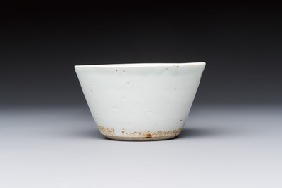 A Chinese white-glazed cup on a wooden stand, 17th C.