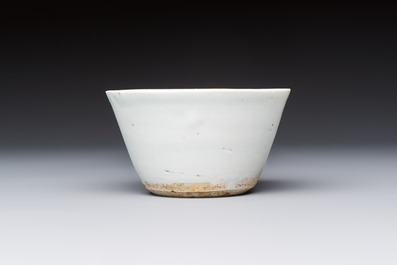 A Chinese white-glazed cup on a wooden stand, 17th C.