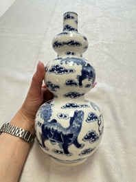 A pair of Chinese blue and white 'Buddhist Lions' triple gourd vases on reticulated wooden stands, 19th C.