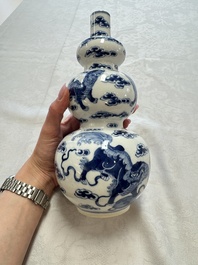 A pair of Chinese blue and white 'Buddhist Lions' triple gourd vases on reticulated wooden stands, 19th C.