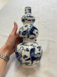 A pair of Chinese blue and white 'Buddhist Lions' triple gourd vases on reticulated wooden stands, 19th C.