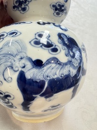 A pair of Chinese blue and white 'Buddhist Lions' triple gourd vases on reticulated wooden stands, 19th C.
