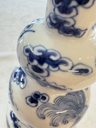 A pair of Chinese blue and white 'Buddhist Lions' triple gourd vases on reticulated wooden stands, 19th C.