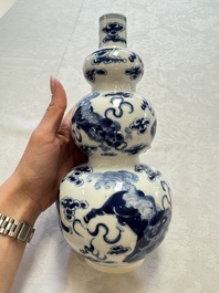 A pair of Chinese blue and white 'Buddhist Lions' triple gourd vases on reticulated wooden stands, 19th C.