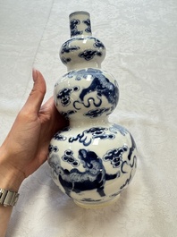 A pair of Chinese blue and white 'Buddhist Lions' triple gourd vases on reticulated wooden stands, 19th C.
