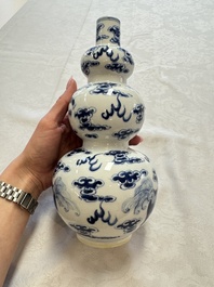 A pair of Chinese blue and white 'Buddhist Lions' triple gourd vases on reticulated wooden stands, 19th C.