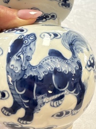 A pair of Chinese blue and white 'Buddhist Lions' triple gourd vases on reticulated wooden stands, 19th C.