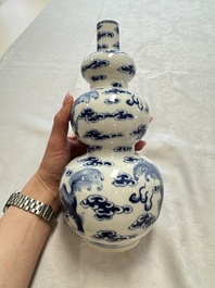 A pair of Chinese blue and white 'Buddhist Lions' triple gourd vases on reticulated wooden stands, 19th C.