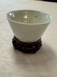 A Chinese white-glazed cup on a wooden stand, 17th C.