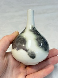A Chinese copper-red and white 'Mythical Beasts' vase and a yellow-glazed bottle vase, on later wooden stands, Kangxi and later
