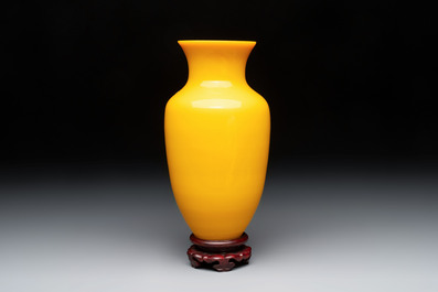A Chinese yellow Peking glass vase on a wooden stand, 19th C.
