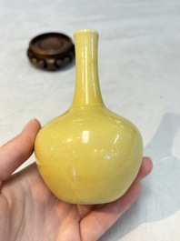 A Chinese copper-red and white 'Mythical Beasts' vase and a yellow-glazed bottle vase, on later wooden stands, Kangxi and later